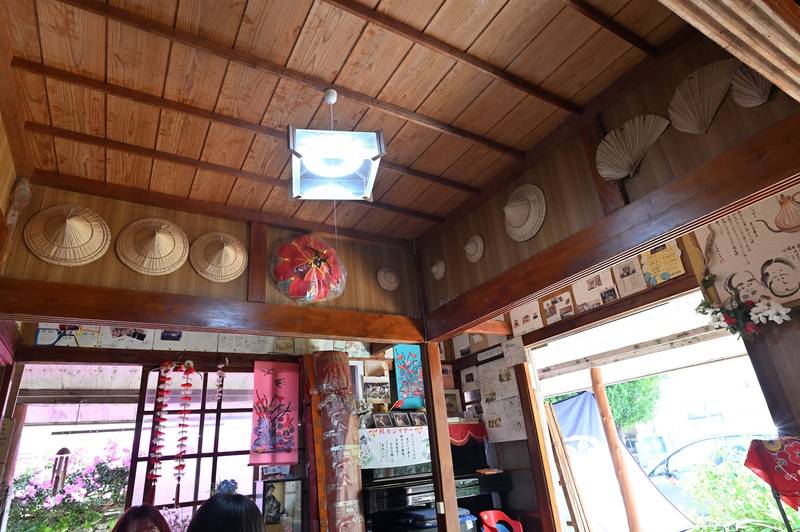 クバ笠や飾りが掛かる木の店内